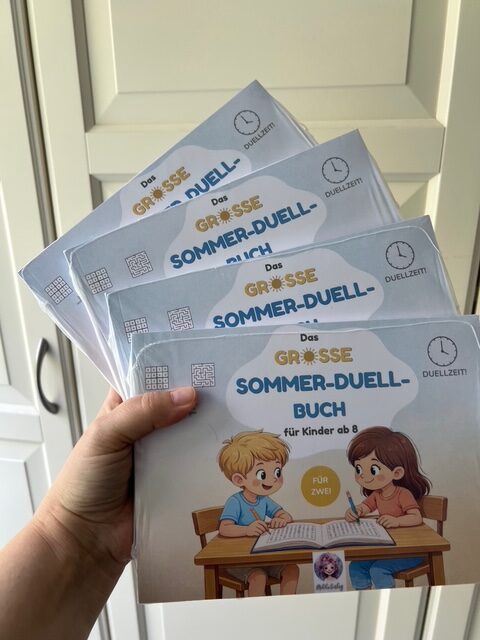 Sommer-Duellbücher in der Hand aufgefächert